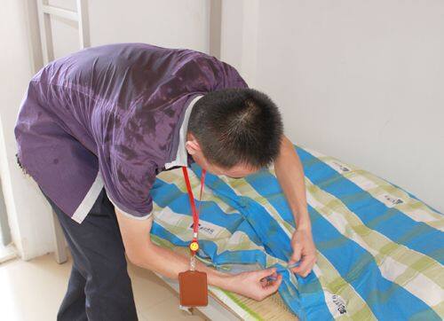 班主任正在帮学生整理床铺