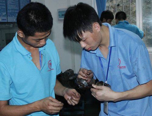 伍小红同学（右）正在和同学认真讨论汽车活塞的问题